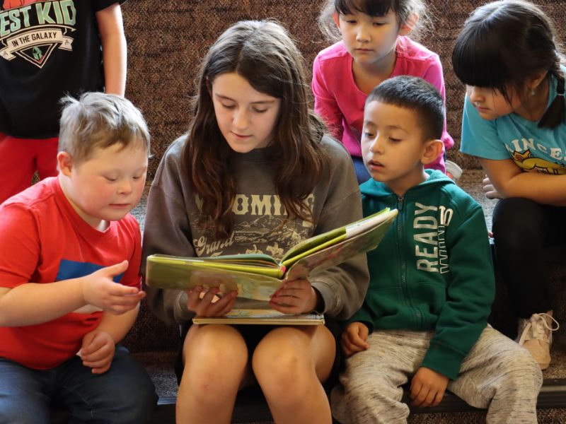 Kaydence reads with kindergarten students.