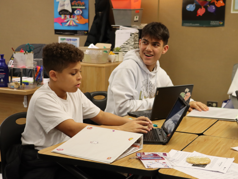 Students in class work on an assignment using their laptops