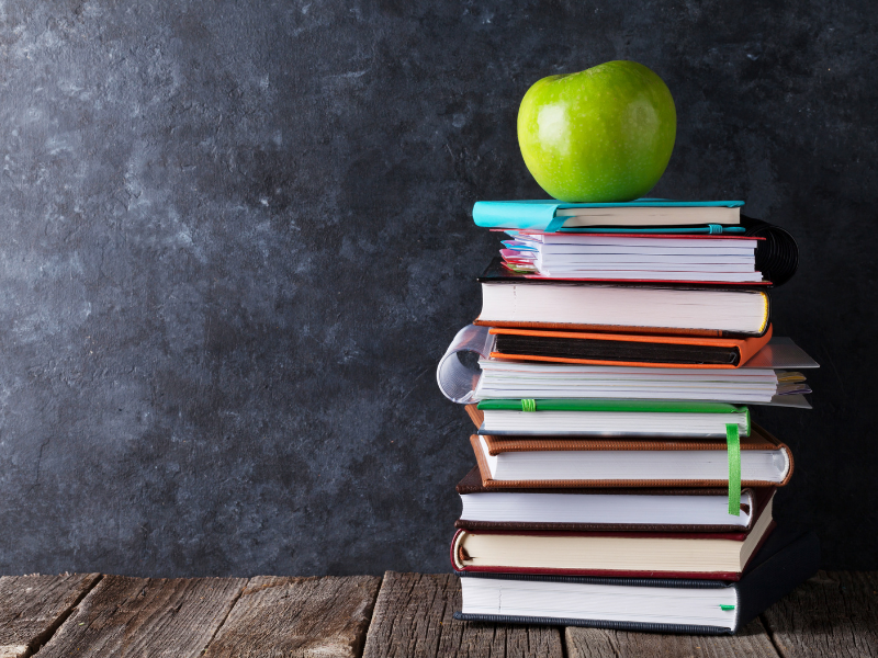 Book and apple, in front of chalk board